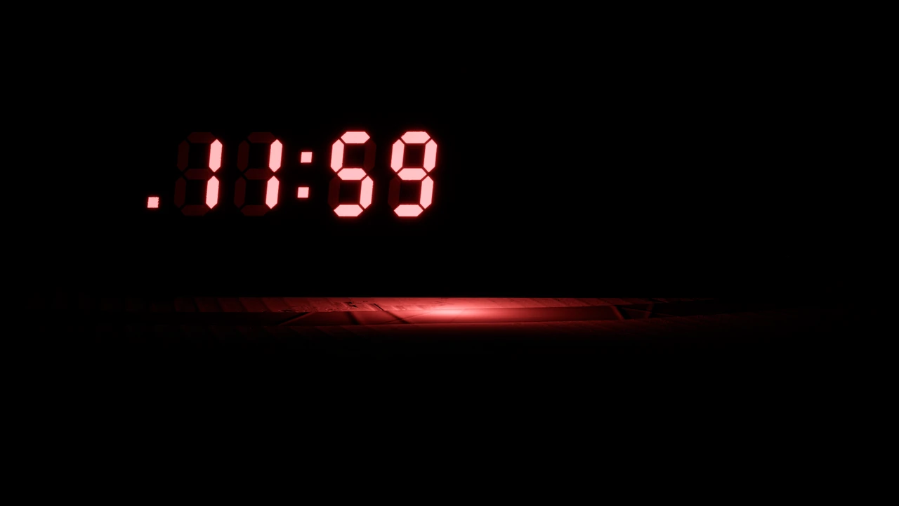 Red digits glowing in the dark: 11:59, with the PM dot lit.