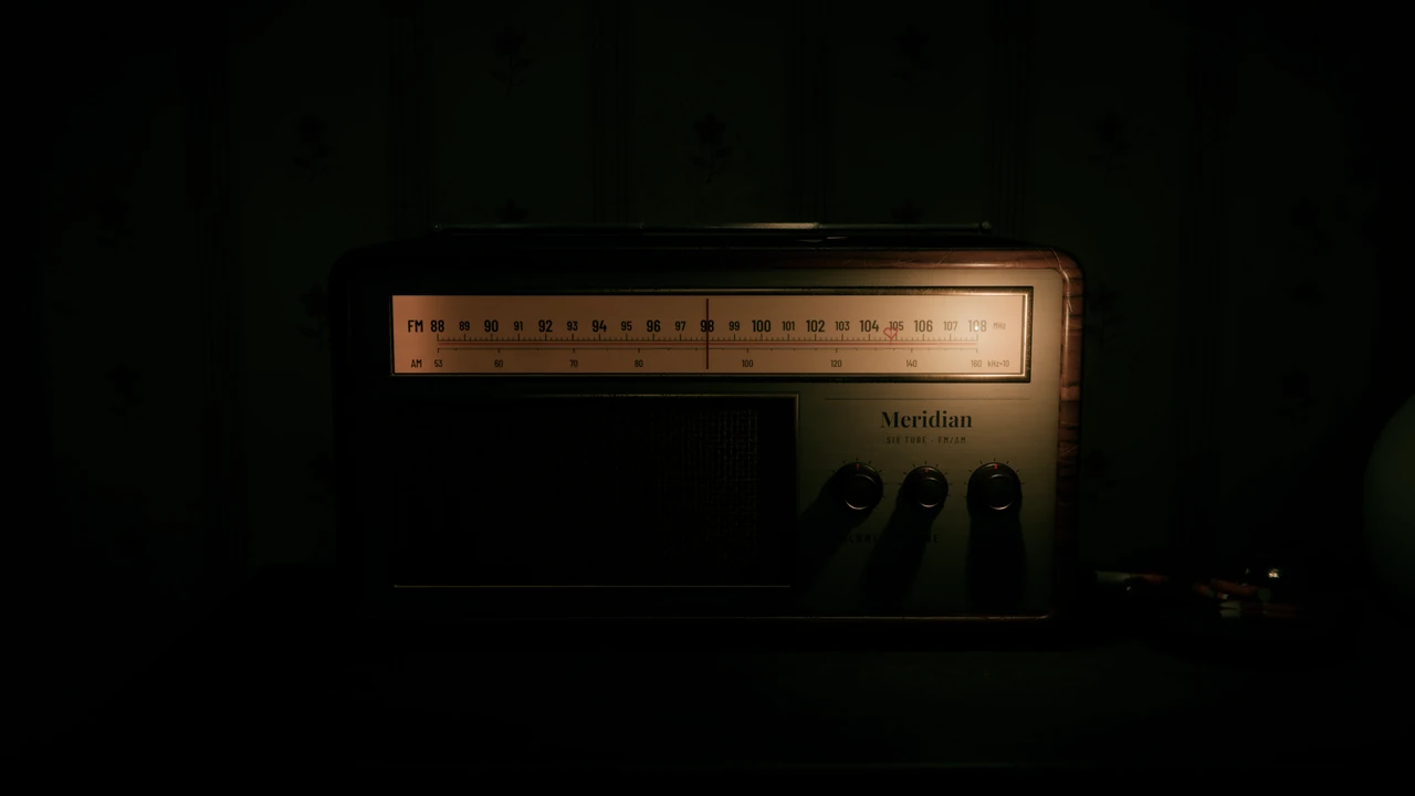 An old valve radio in the dark, its glowing tuning scale the only light in the room.