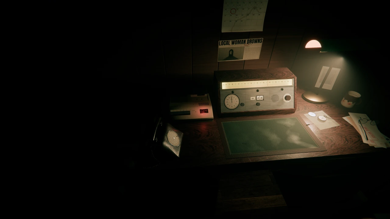 A desk in a dark study: a banker's lamp, an old radio set with a dial lock, a cassette answering machine, a newspaper clipping and a calendar on the wall.